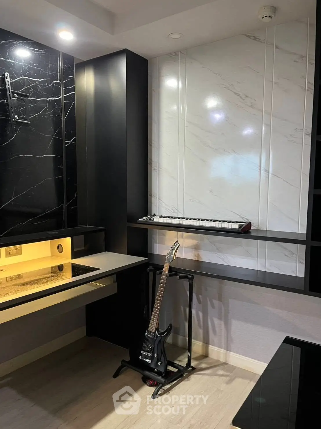 Stylish modern study room with sleek black and white decor, featuring a guitar and keyboard for music enthusiasts.