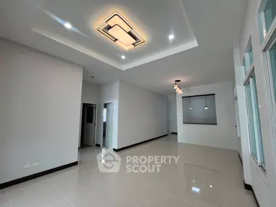 Spacious modern living room with elegant ceiling lights and large windows