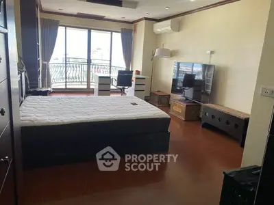 Spacious bedroom with balcony access and modern furnishings in a luxurious apartment.