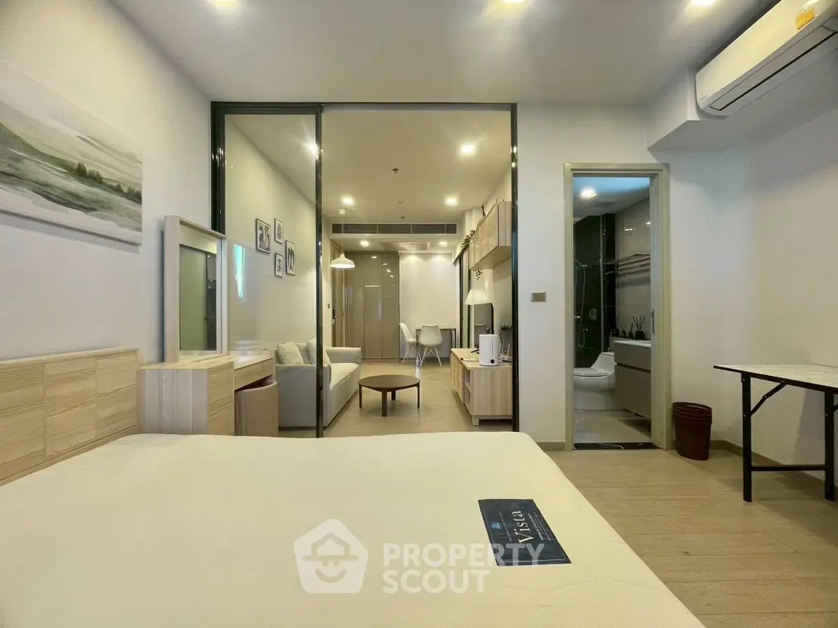 Modern studio apartment with open layout, featuring a cozy living area, dining space, and stylish bathroom.
