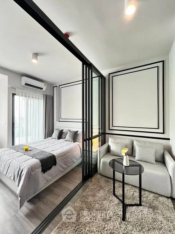 Modern bedroom with glass partition and cozy seating area in stylish apartment