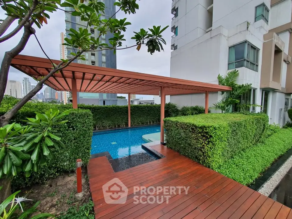 Luxurious urban apartment with serene pool and lush greenery, perfect for relaxation and city living.