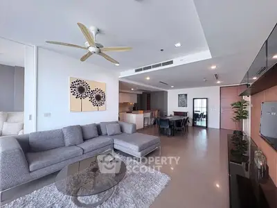 Spacious modern living room with elegant decor and open kitchen layout.