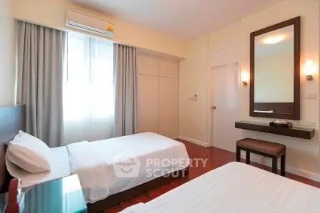 Spacious twin bedroom with modern decor and ample natural light