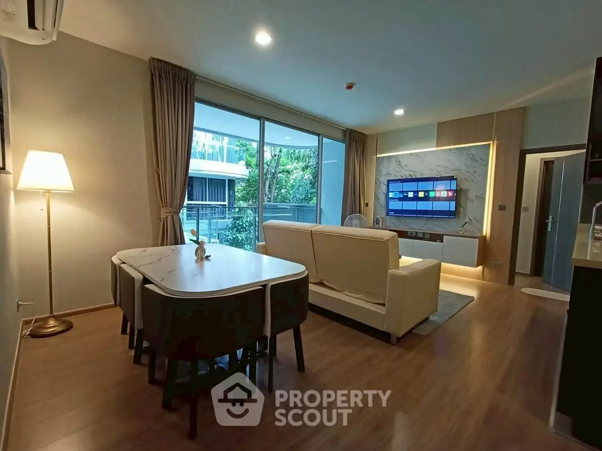 Spacious modern living room with elegant decor and large windows offering a serene view.