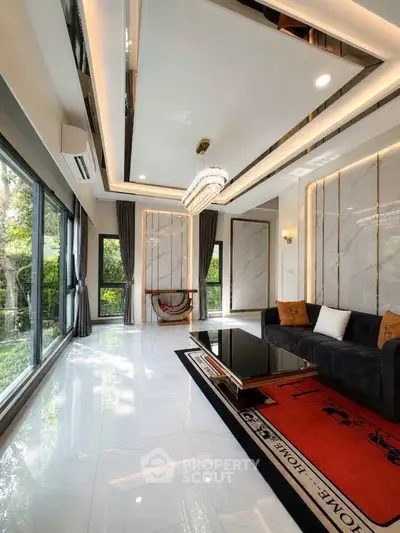 Luxurious living room with modern decor, large windows, and elegant chandelier.