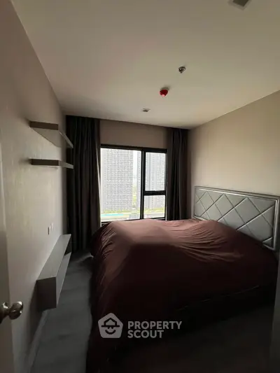 Cozy bedroom with large window and modern decor in urban apartment