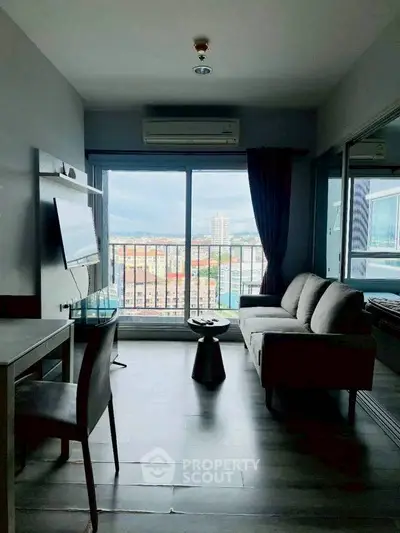 Modern living room with city view, featuring sleek furniture and large windows for natural light.