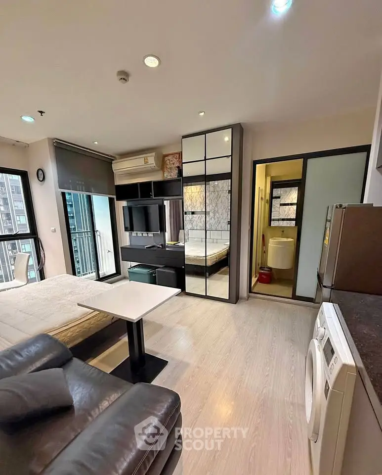 Modern studio apartment with sleek furnishings and open layout in urban setting.
