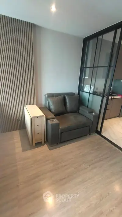 Modern living room with sleek glass partition and cozy seating area