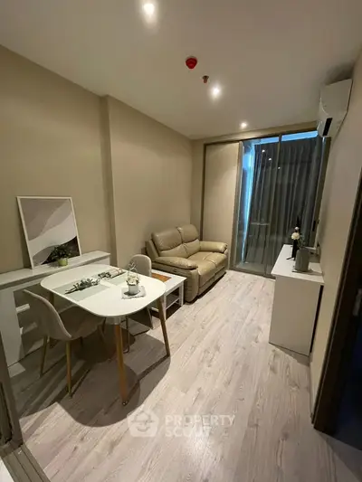 Modern living room with sleek furniture and balcony access in a stylish apartment.