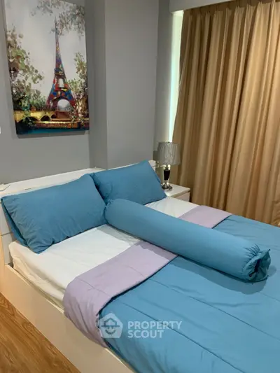 Cozy bedroom with modern decor and vibrant blue bedding, perfect for relaxation.