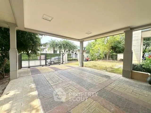 Spacious covered parking area with garden view in modern residential property.