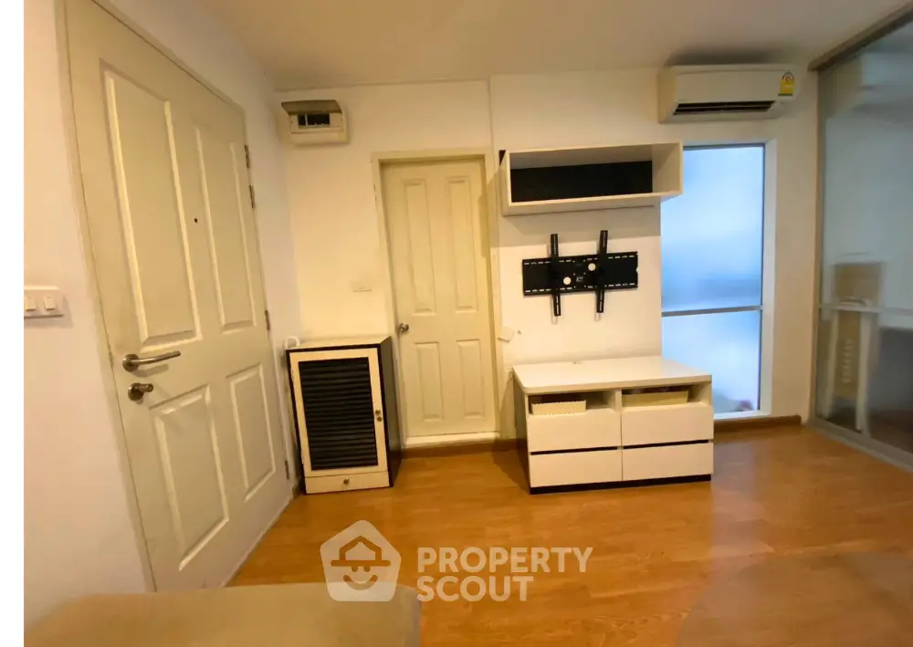 Modern apartment interior with wooden flooring and wall-mounted TV stand