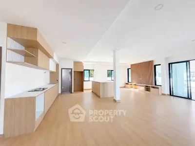 Spacious open-plan living area with modern kitchen and large windows