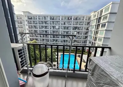 Modern apartment balcony with pool view in a stylish residential complex.