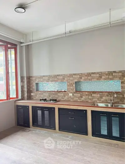 Modern kitchen with gas stove and stylish backsplash in a bright apartment
