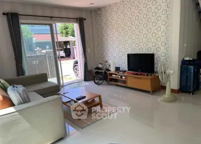 Bright living room with modern decor and sliding glass doors leading to outdoor area.