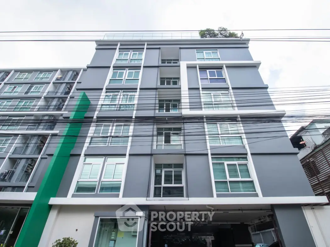 Modern multi-story apartment building with sleek design and large windows.
