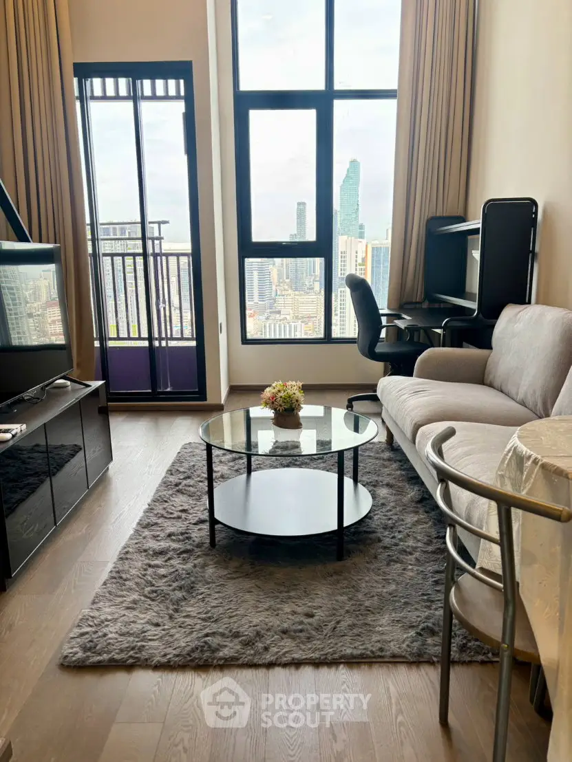 Modern living room with city view, featuring cozy seating and stylish decor in a high-rise apartment.