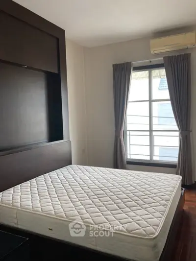 Cozy bedroom with large window and modern air conditioning unit