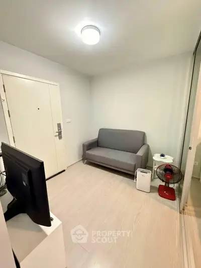 Cozy living room with modern sofa and TV setup in a compact apartment