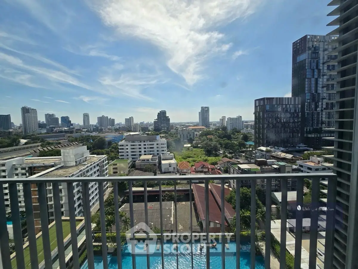 Stunning cityscape view from a high-rise balcony overlooking urban skyline and pool.