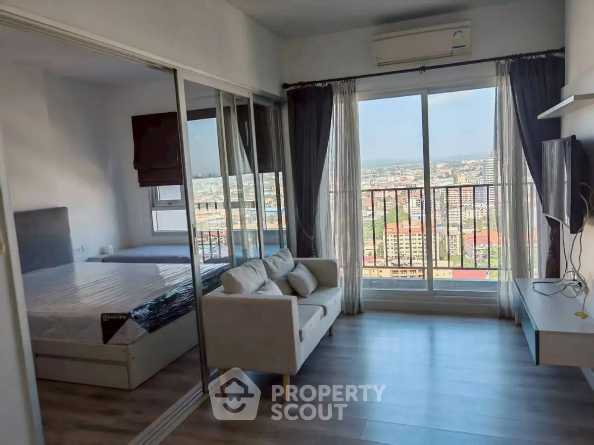 Modern apartment with stunning city view, featuring a cozy living area and bedroom with large windows.