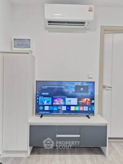 Modern living room with sleek TV setup and air conditioning unit, perfect for comfortable living.