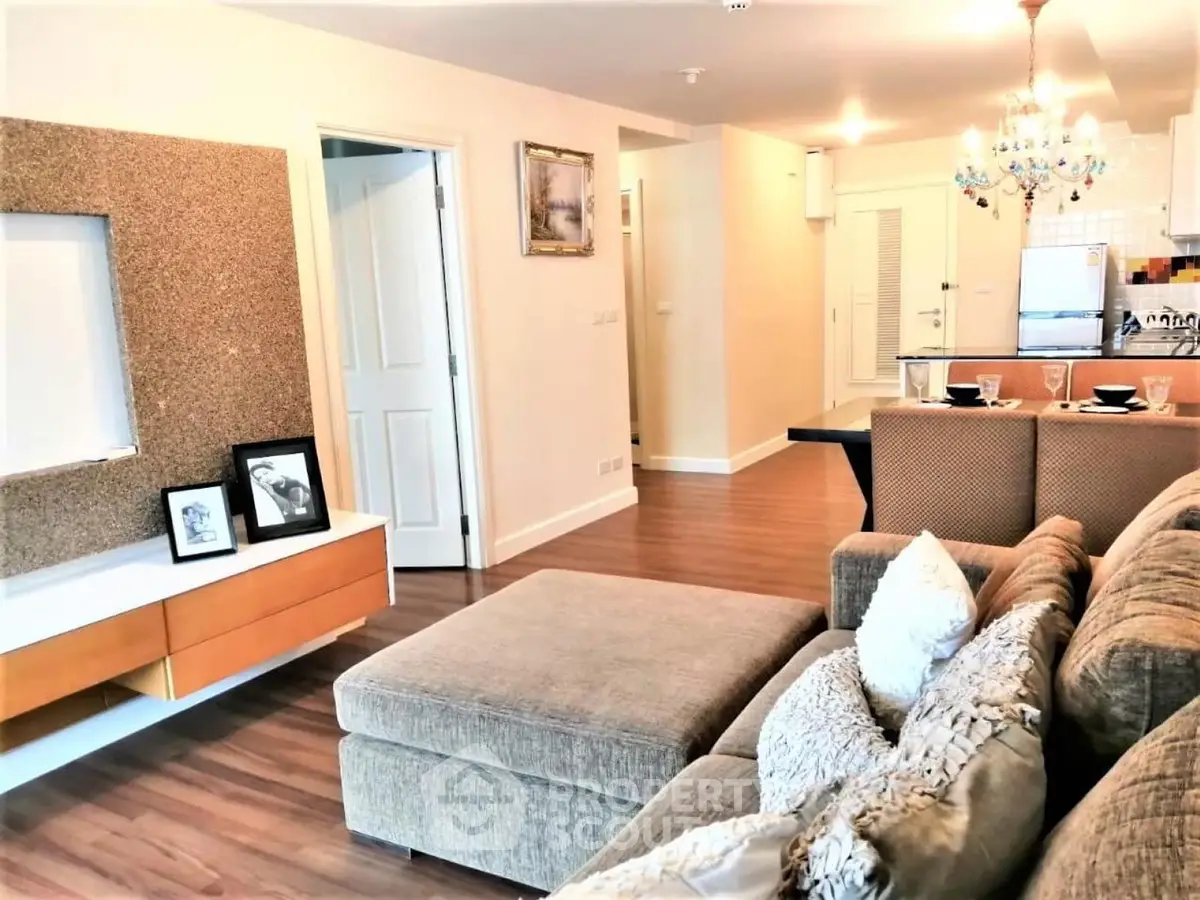 Spacious living room with modern decor and open kitchen layout, perfect for entertaining.