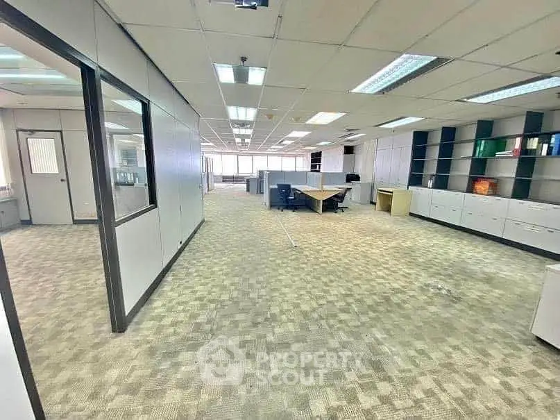 Spacious open-plan office with modern design and ample natural light.