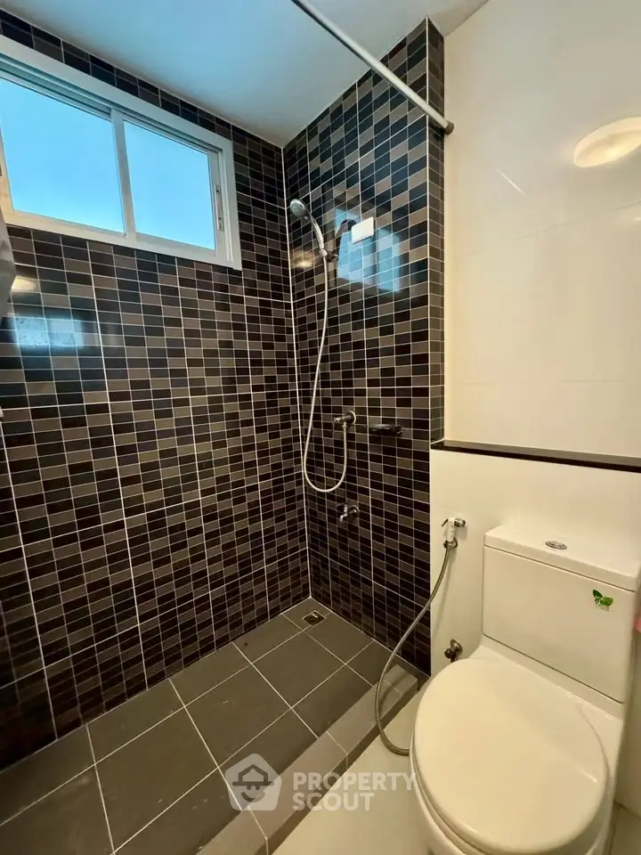 Modern bathroom with sleek black tiles and walk-in shower