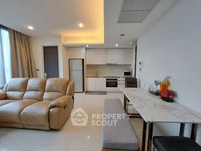 Modern open-layout living room with sleek kitchen and cozy seating area