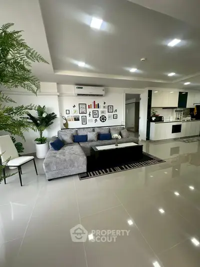 Spacious modern living room with sleek design and open kitchen layout.