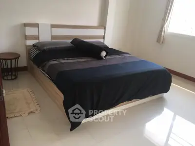 Modern bedroom with stylish bed and natural light, perfect for relaxation.