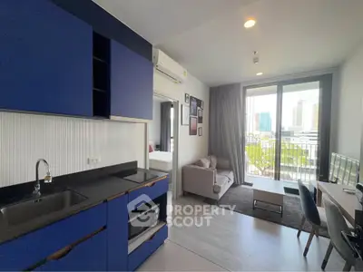Modern open-layout apartment with sleek kitchen and cozy living area, featuring a balcony with city views.