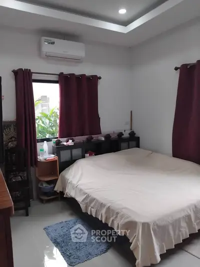 Cozy bedroom with large bed and natural light from window