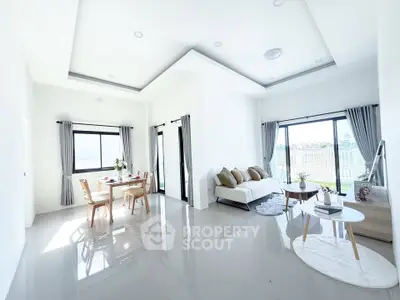 Spacious modern living room with dining area and large windows offering natural light.