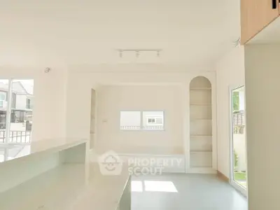 Bright and spacious modern living room with built-in shelves and large windows.