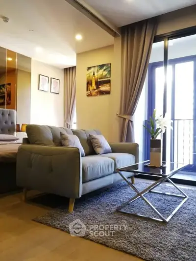 Modern living room with cozy sofa, stylish decor, and balcony access in urban apartment.