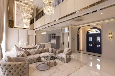 Luxurious living room with high ceilings, elegant chandeliers, and plush furniture in a modern open layout.