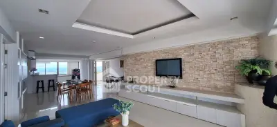 Spacious modern living room with stylish decor and open layout, featuring a stone accent wall and large windows.