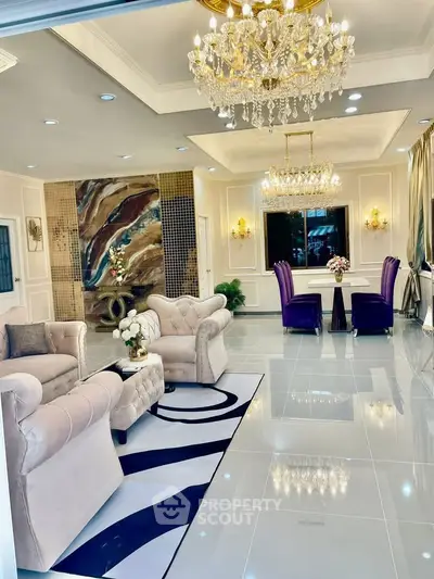 Luxurious living room with elegant chandeliers and plush seating in a modern open layout.