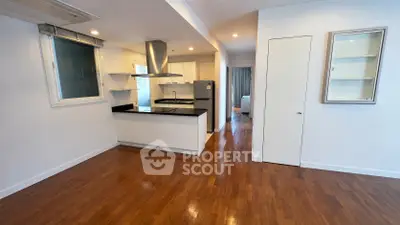 Spacious open-plan kitchen and living area with sleek wooden flooring and modern appliances.