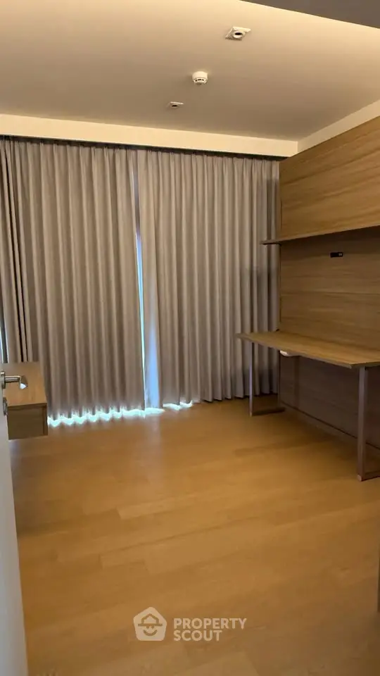 Spacious study room with wooden flooring and modern desk setup