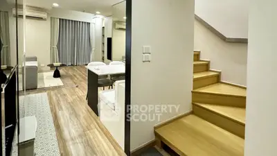 Modern duplex apartment with stylish living area and wooden staircase