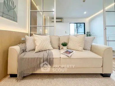 Modern living room with cozy beige sofa and stylish decor in a bright apartment.