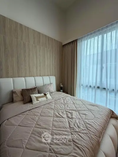 Cozy bedroom with elegant decor and large window for natural light