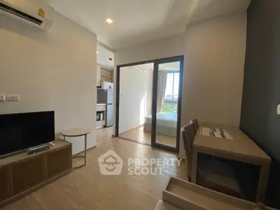 Modern apartment interior with open layout, featuring a cozy living area and a glimpse of the bedroom.