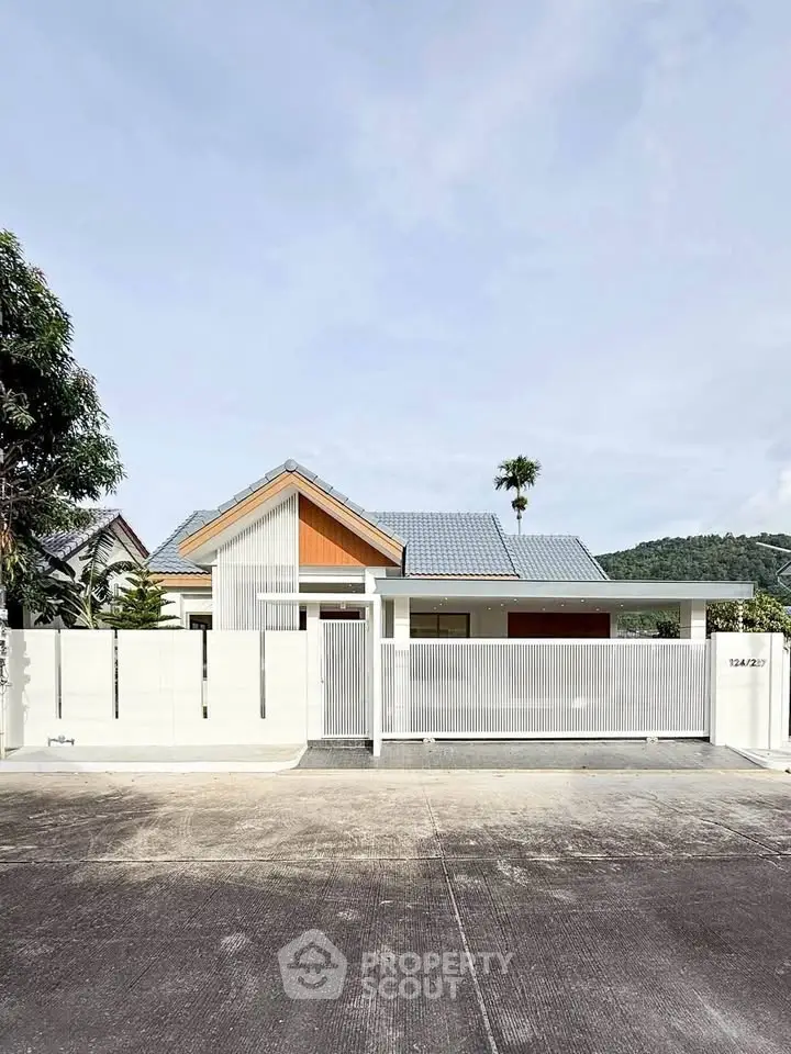 Charming modern house with sleek white facade and spacious driveway in a serene neighborhood.